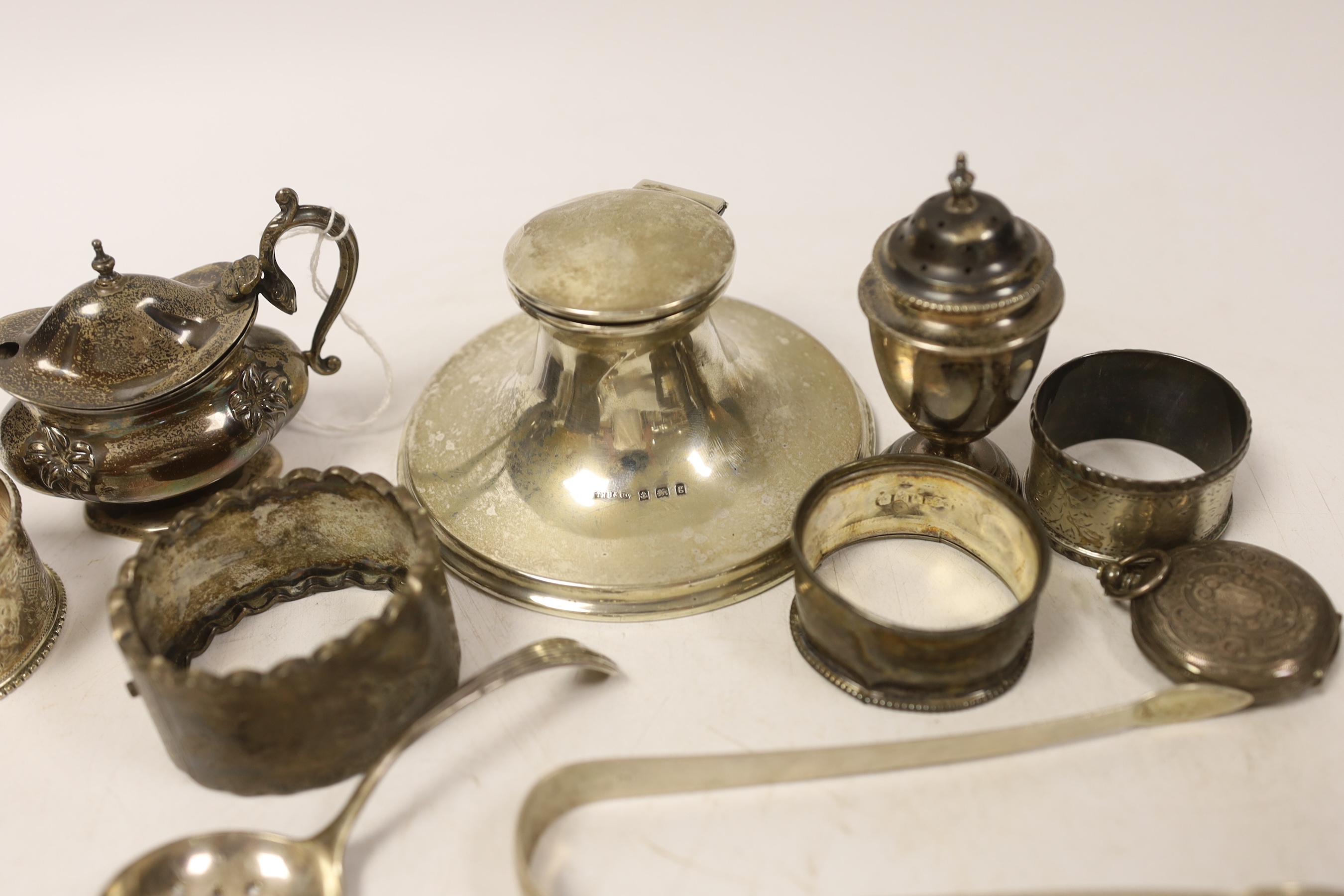 Sundry small silver including a capstan inkwell, napkin rings, condiments, fob watch and pair of Georgian sugar tongs.